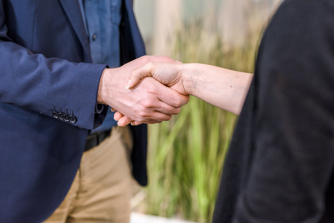 Visionaer Referenz: netpartner Fotografie Mitarbeiter Handschütteln